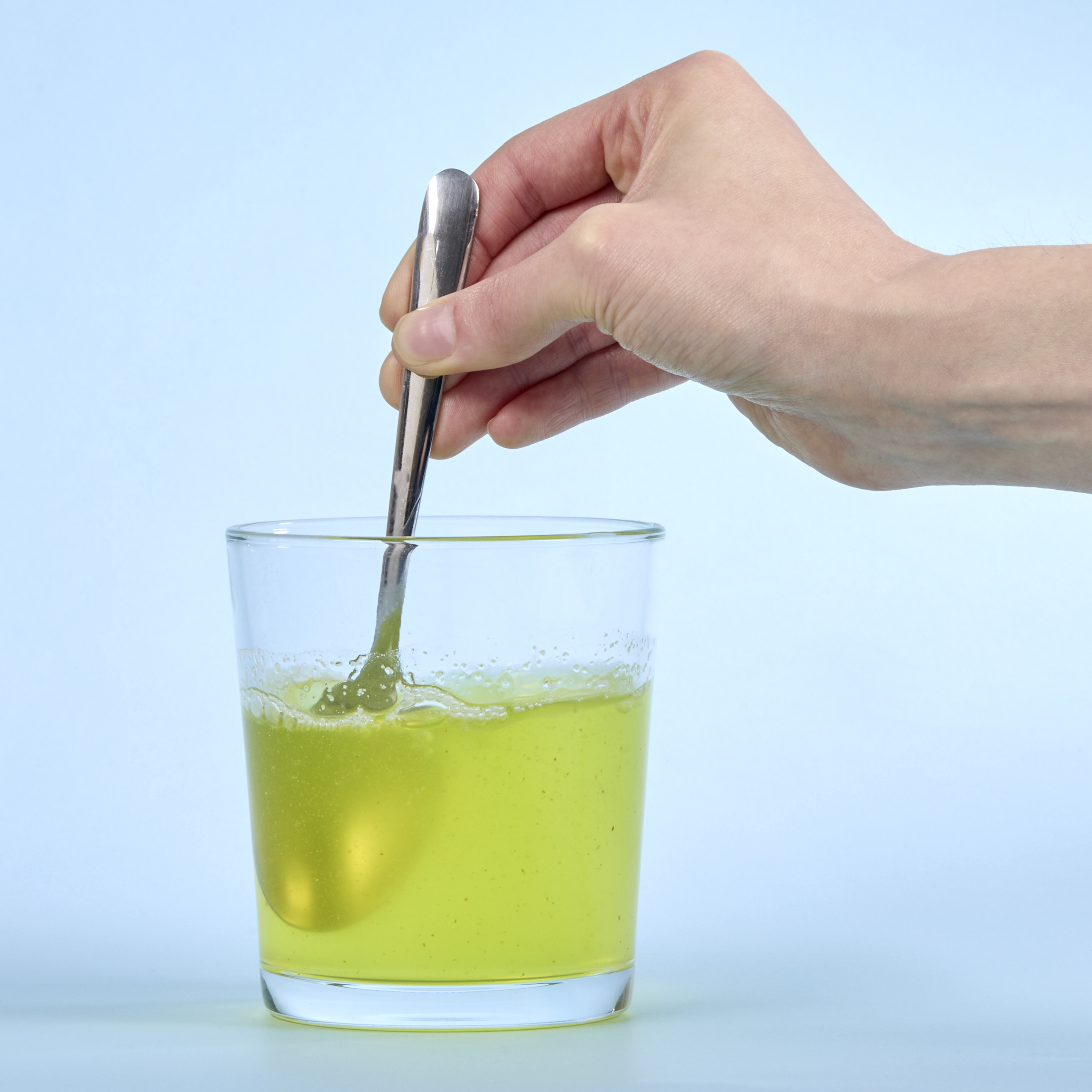 image of a person stirring Isotonix Digestive Enzymes in water.