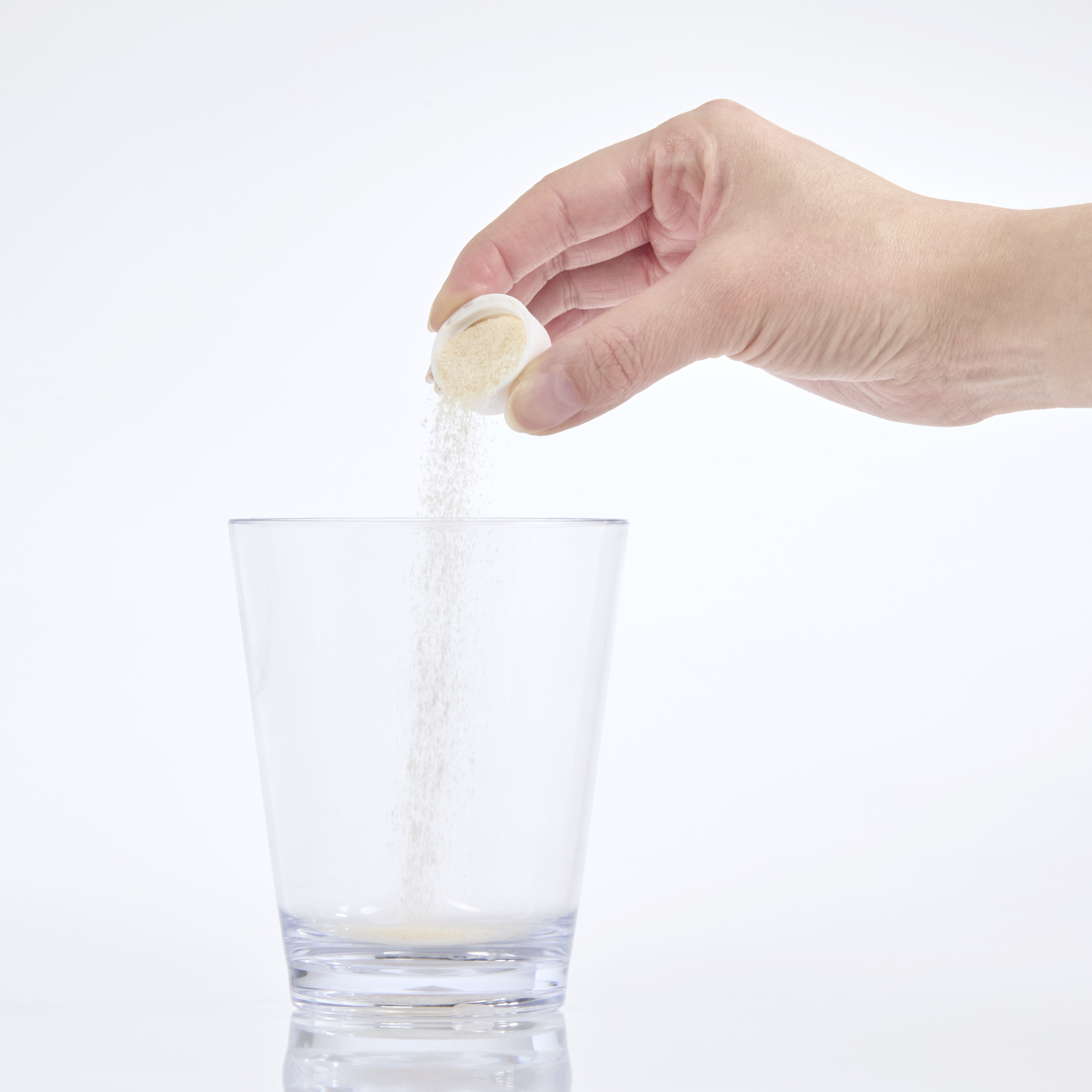 image of a capful of powder being added to glass