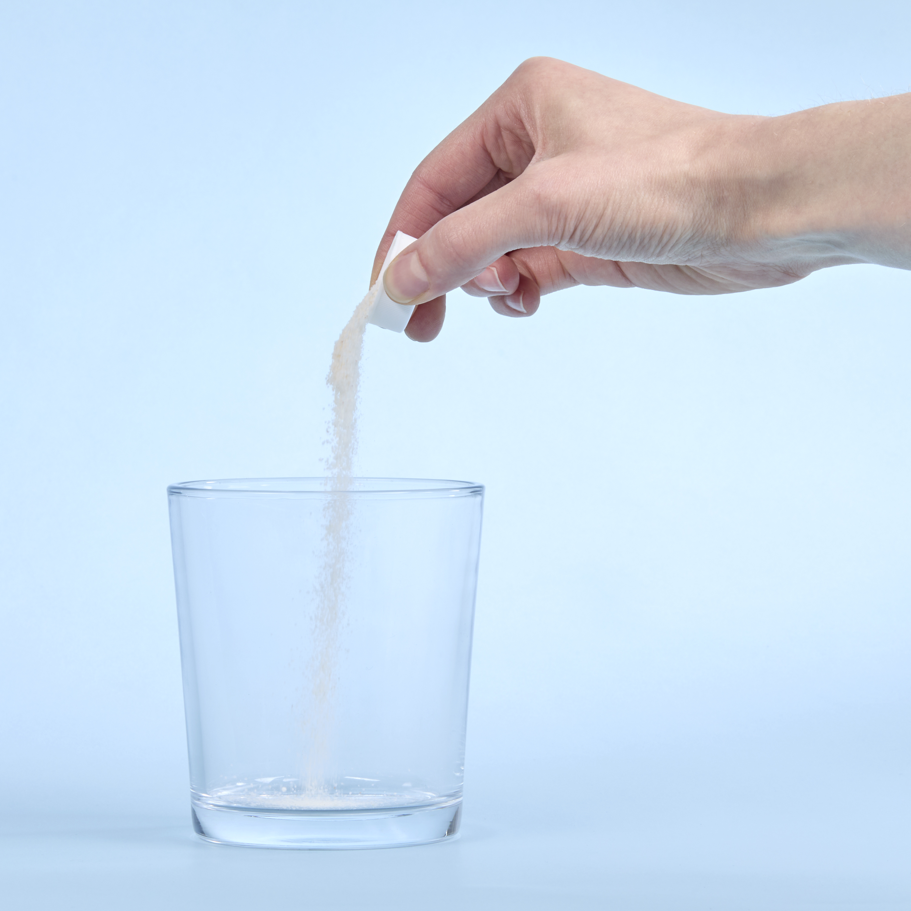 image of person pouring capful of Isotonix into a glass