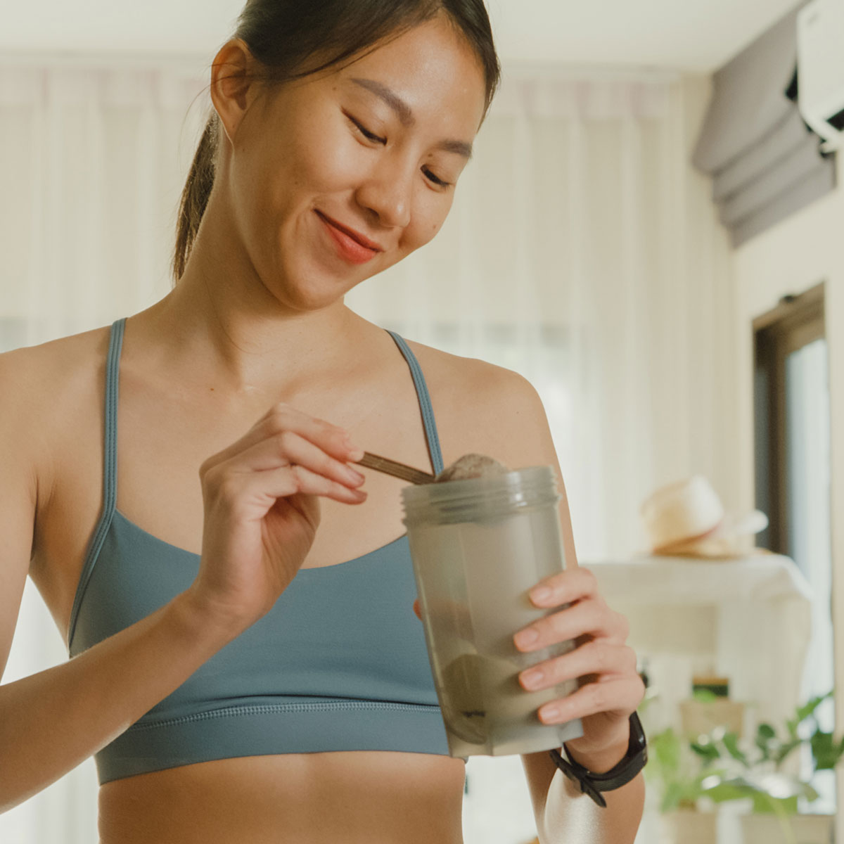 person adding two scoops of GoTrim Shake to a glass