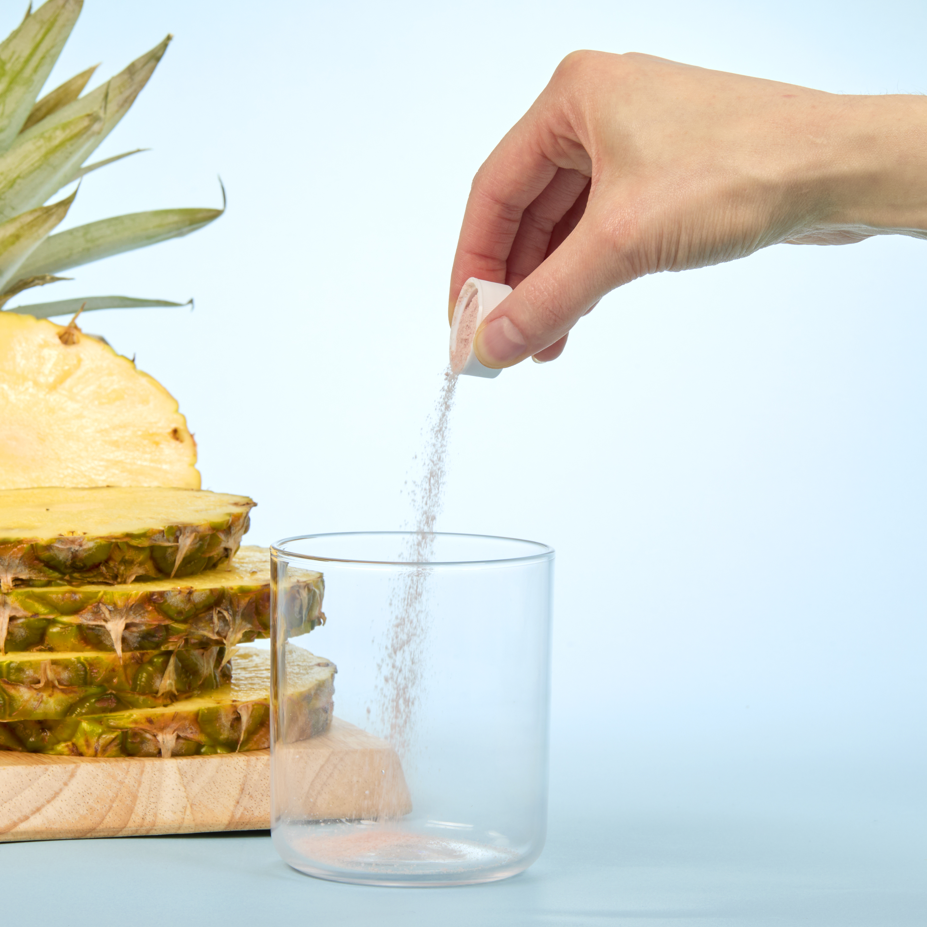 person pouring Isotonix Bromelain powder into a glass