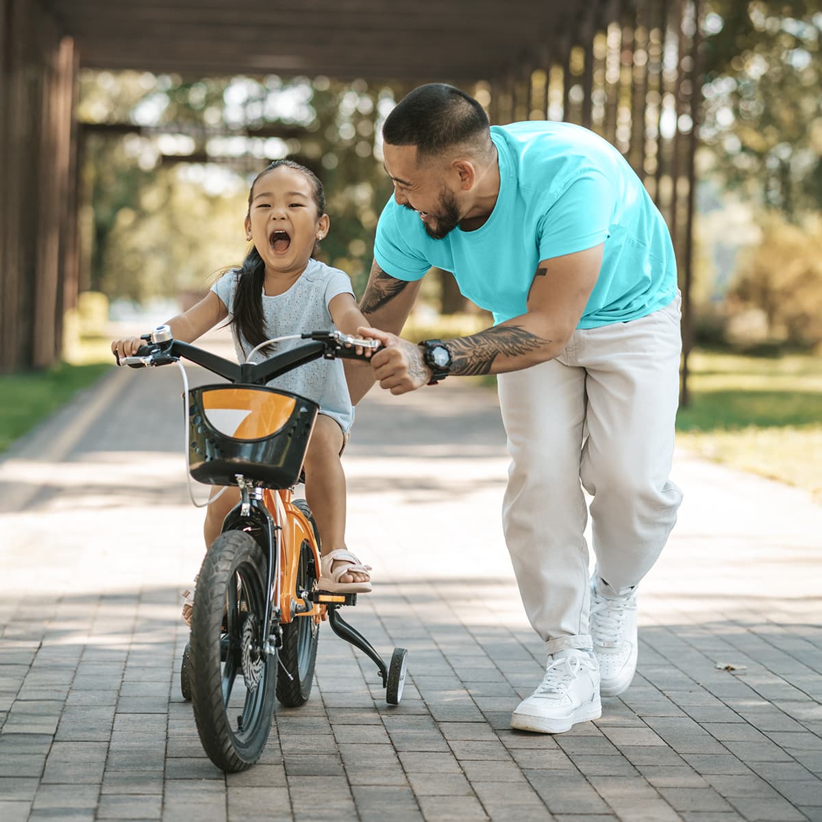 image of an adult teaching child how to ride bike