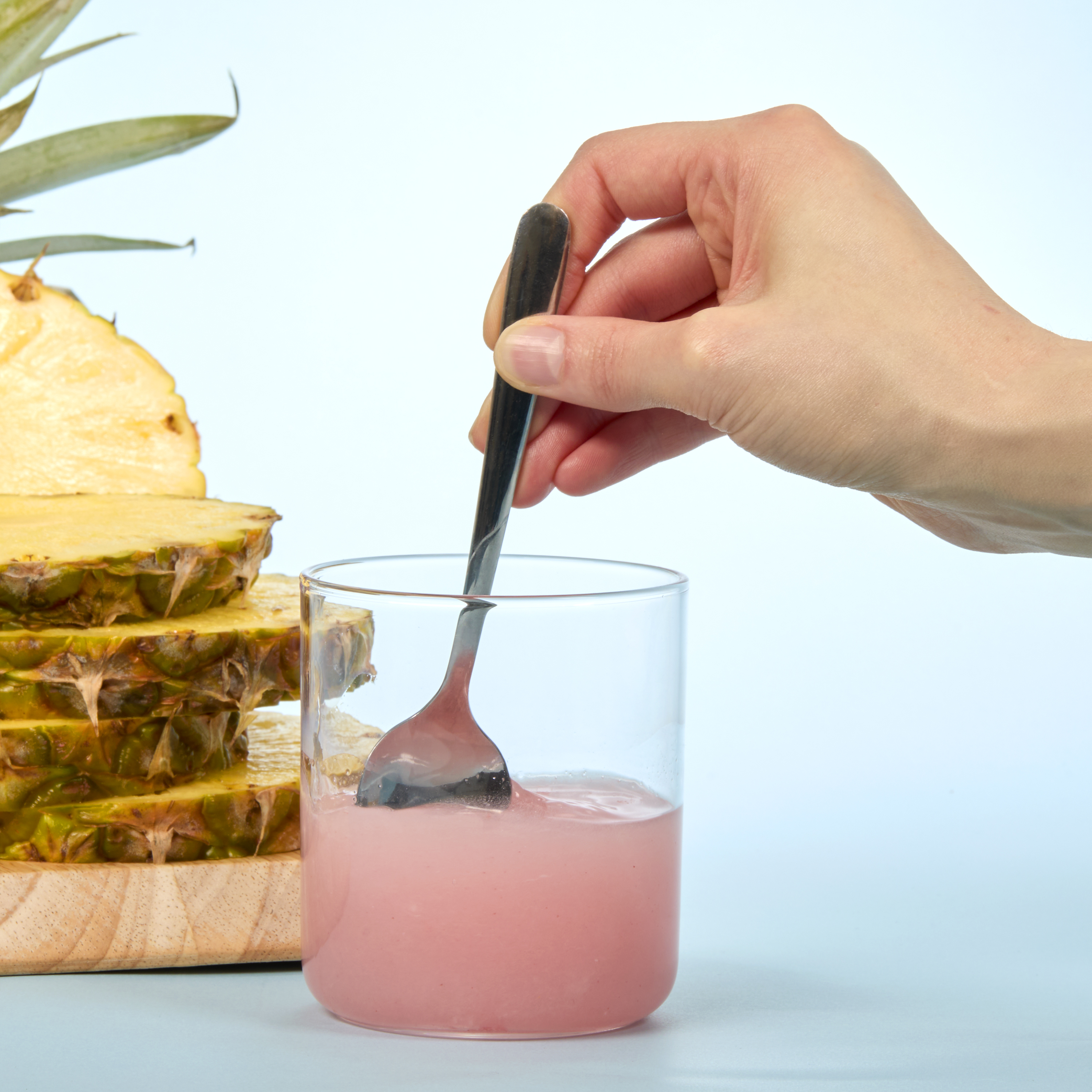 person stirring up Isotonix Bromelain in a glass