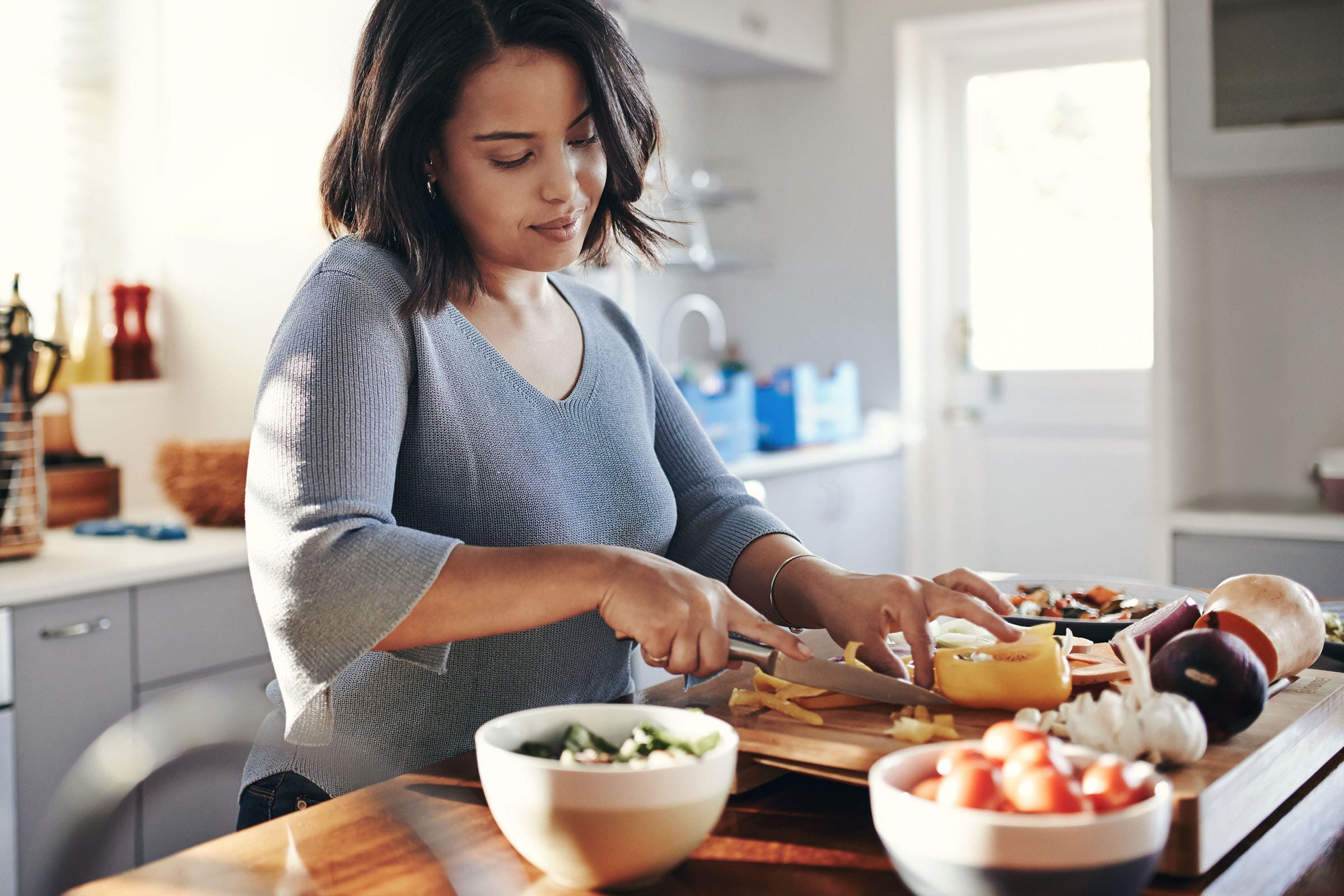 image of woman chopping vegetables in the kitchen