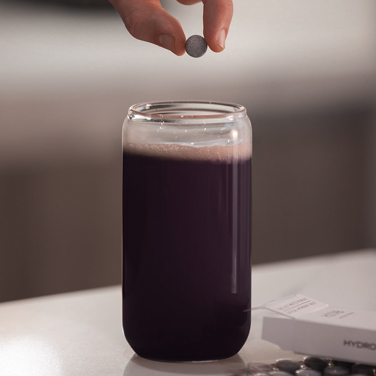 image of H2TAB being dropped into glass of Daily Essentials mix