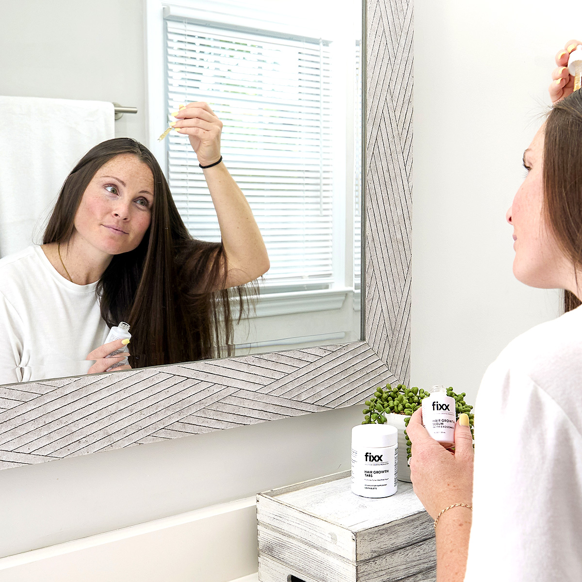 image of woman applying Fixx Hair Growth Serum to their hair