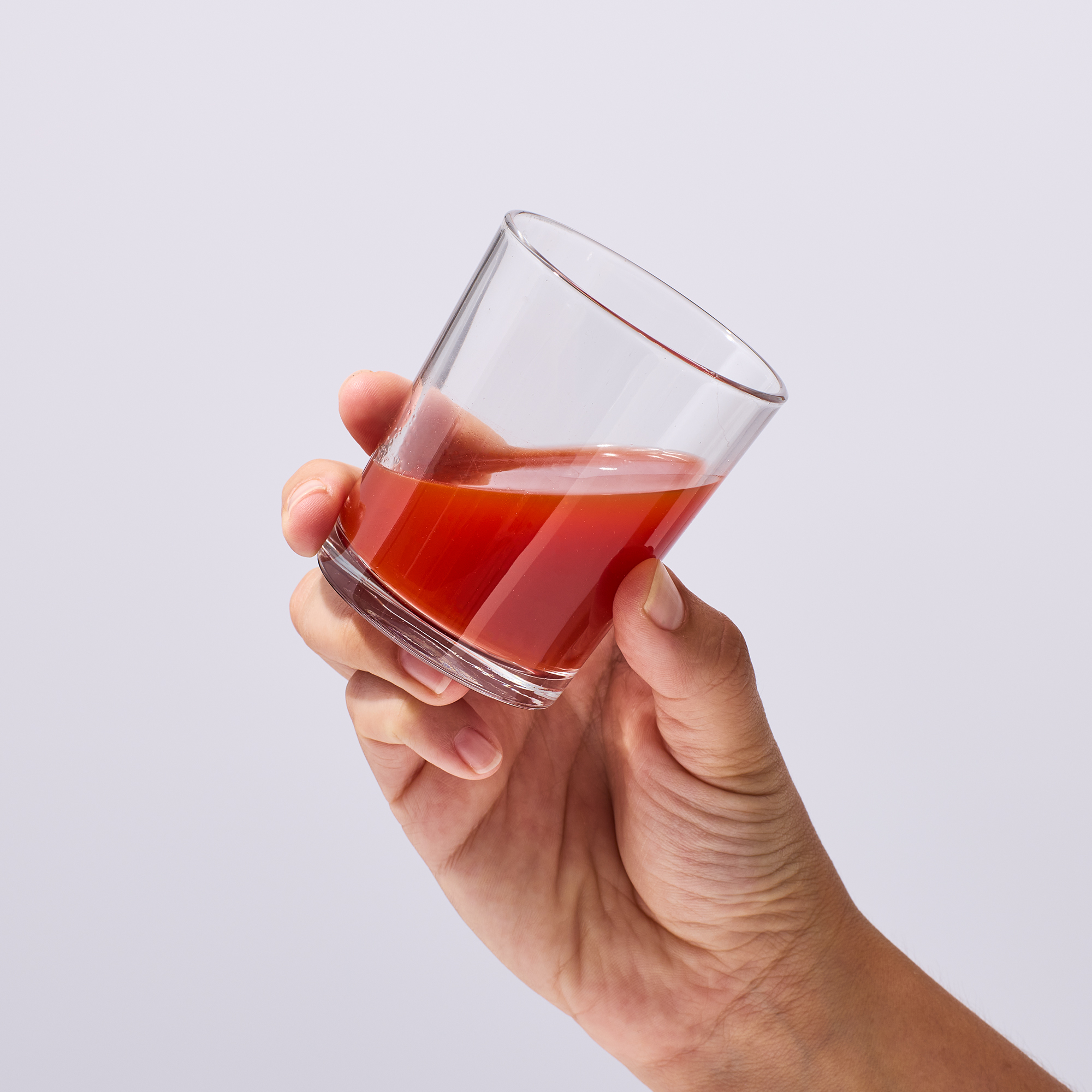 image of person holding a glass with a serving of Isotonix Astaxanthin in it
