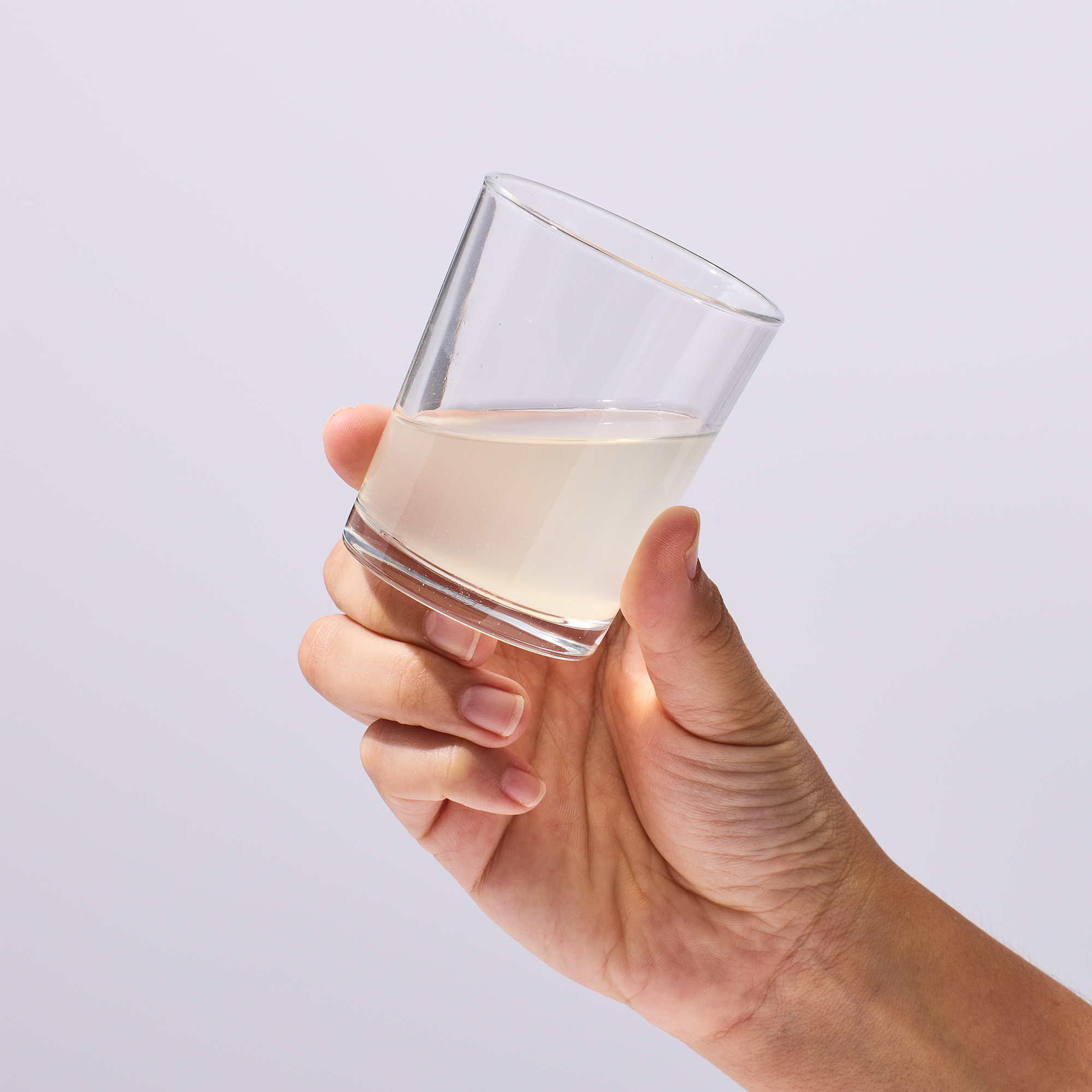 image of a person holding a glass of Isotonix Magnesium about to drink it