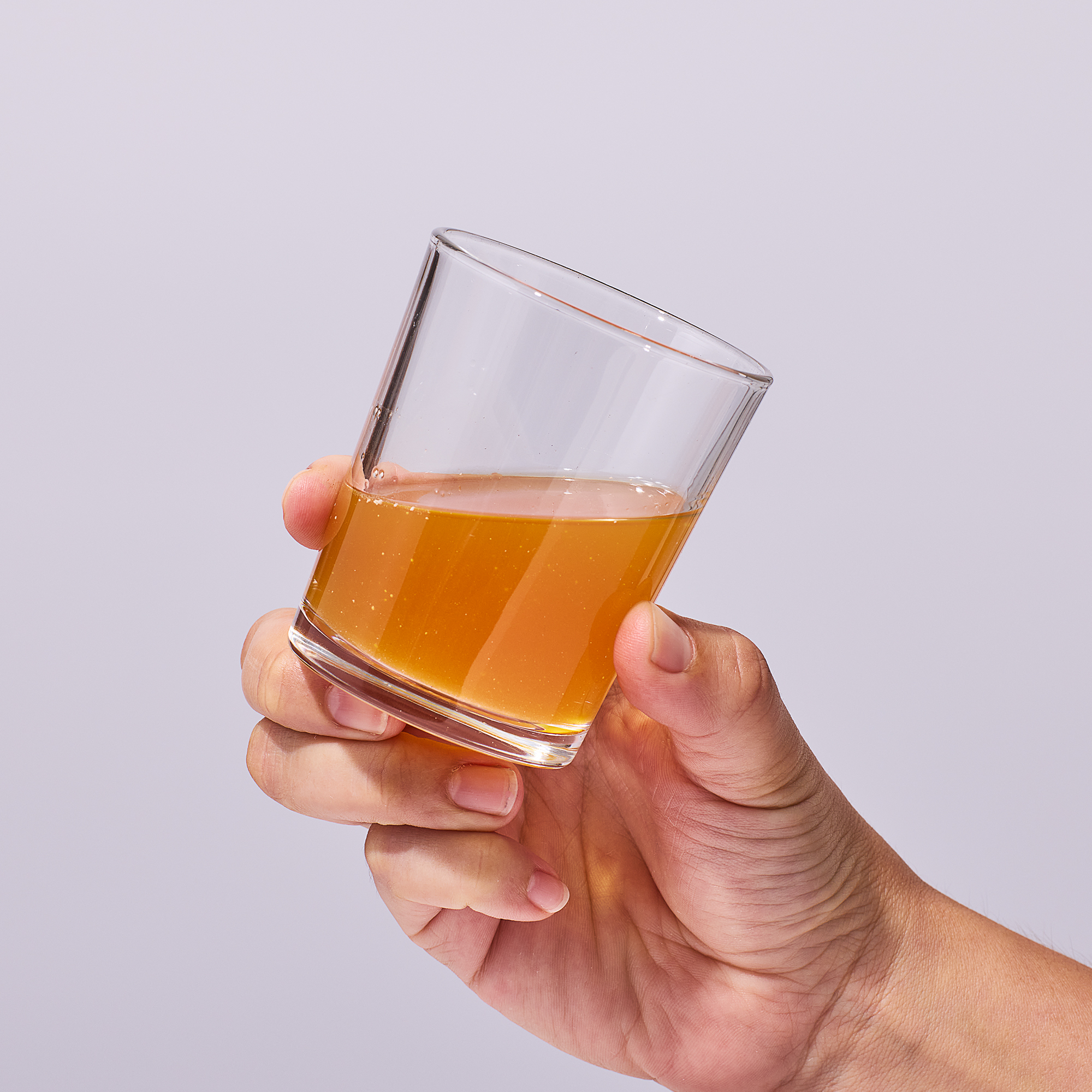 image of person holding a glass containing a serving of Isotonix Multivitamin in their hand