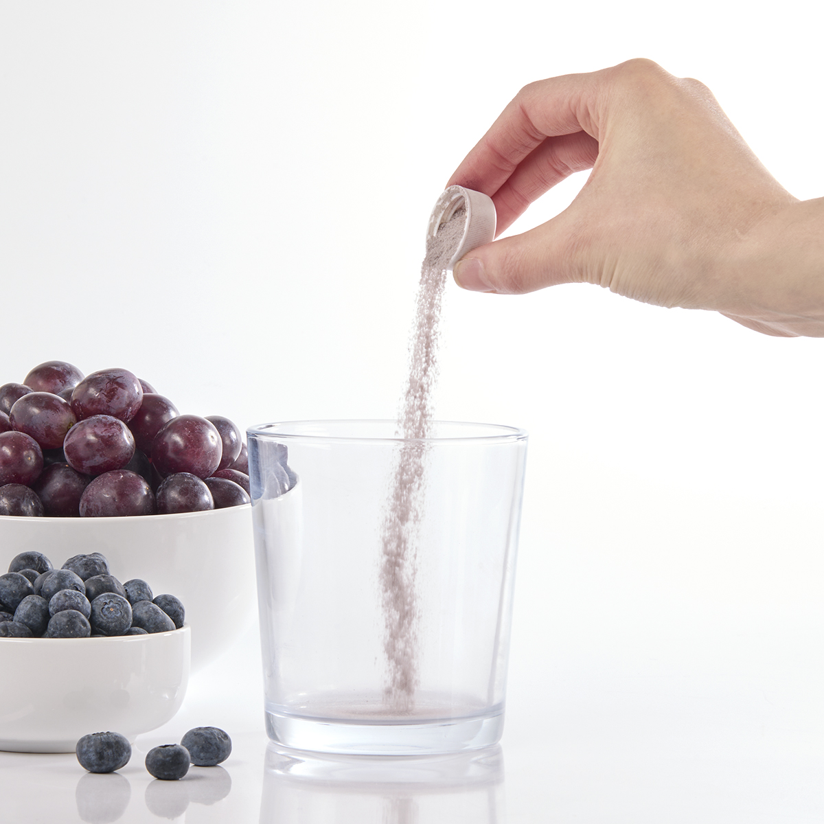 image of capful of powder being added to glass
