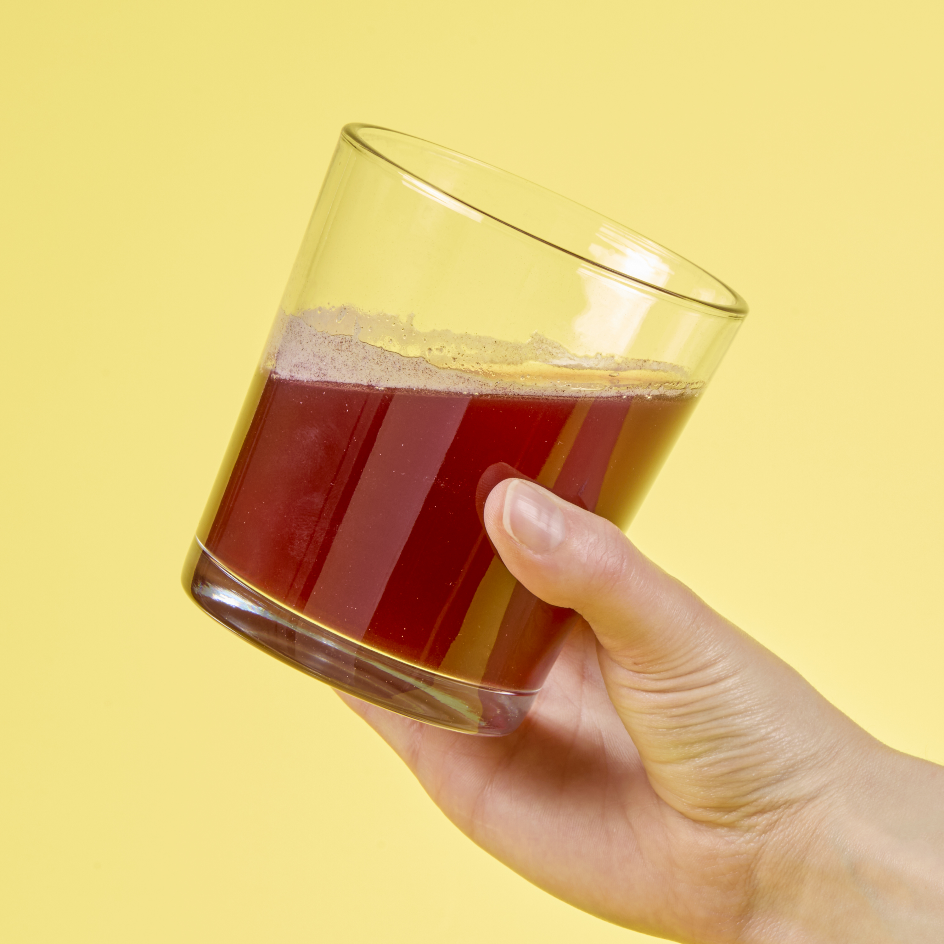 image of hand holding Isotonix Resveratrol liquid in a clear glass