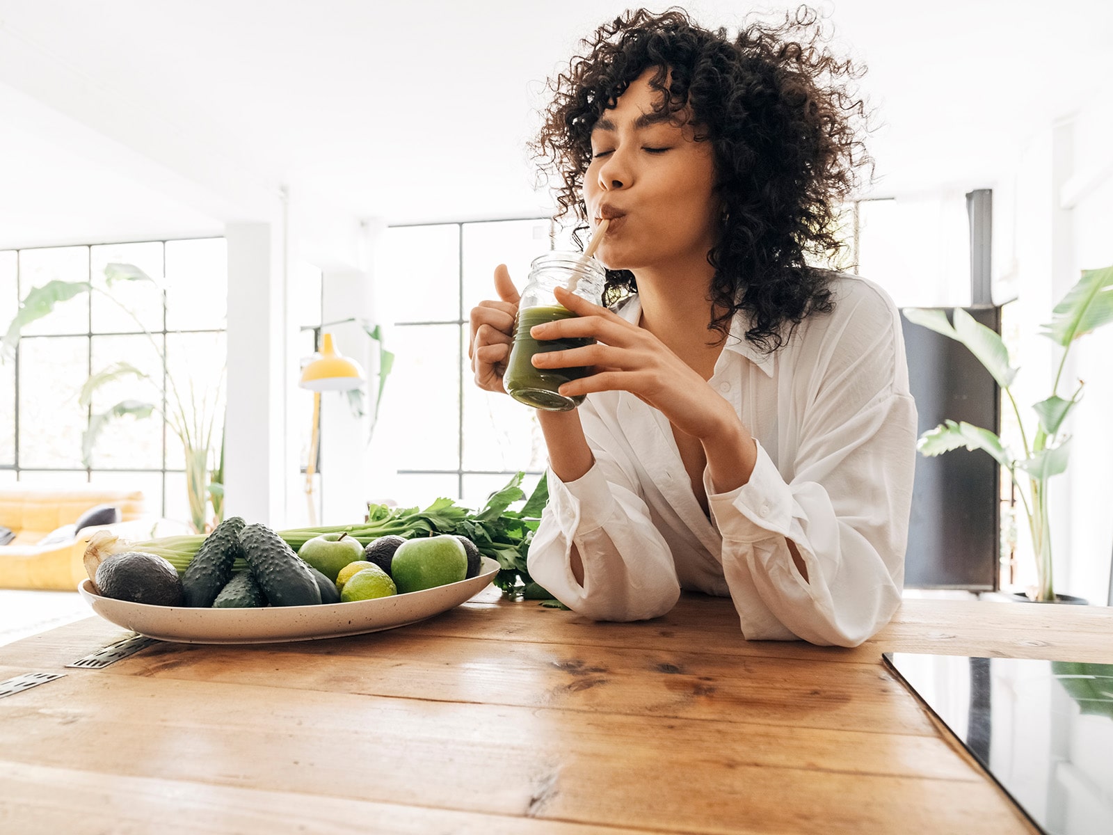 image of person drinking out of a glass with a straw