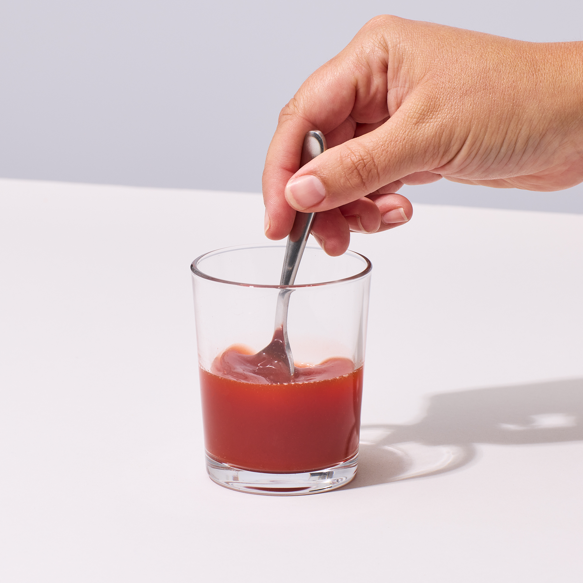image of person's hand mixing a serving of Isotonix Astaxanthin up with water