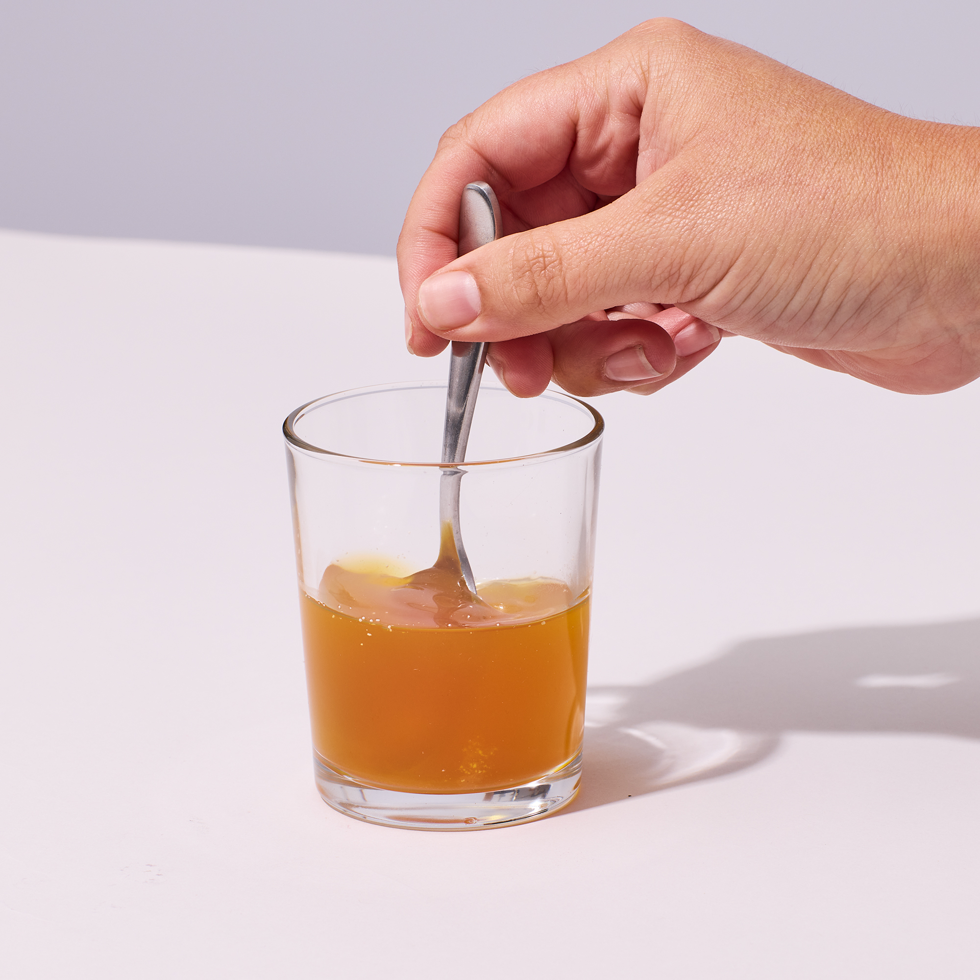 Image of person mixing up powder into the water with a spoon