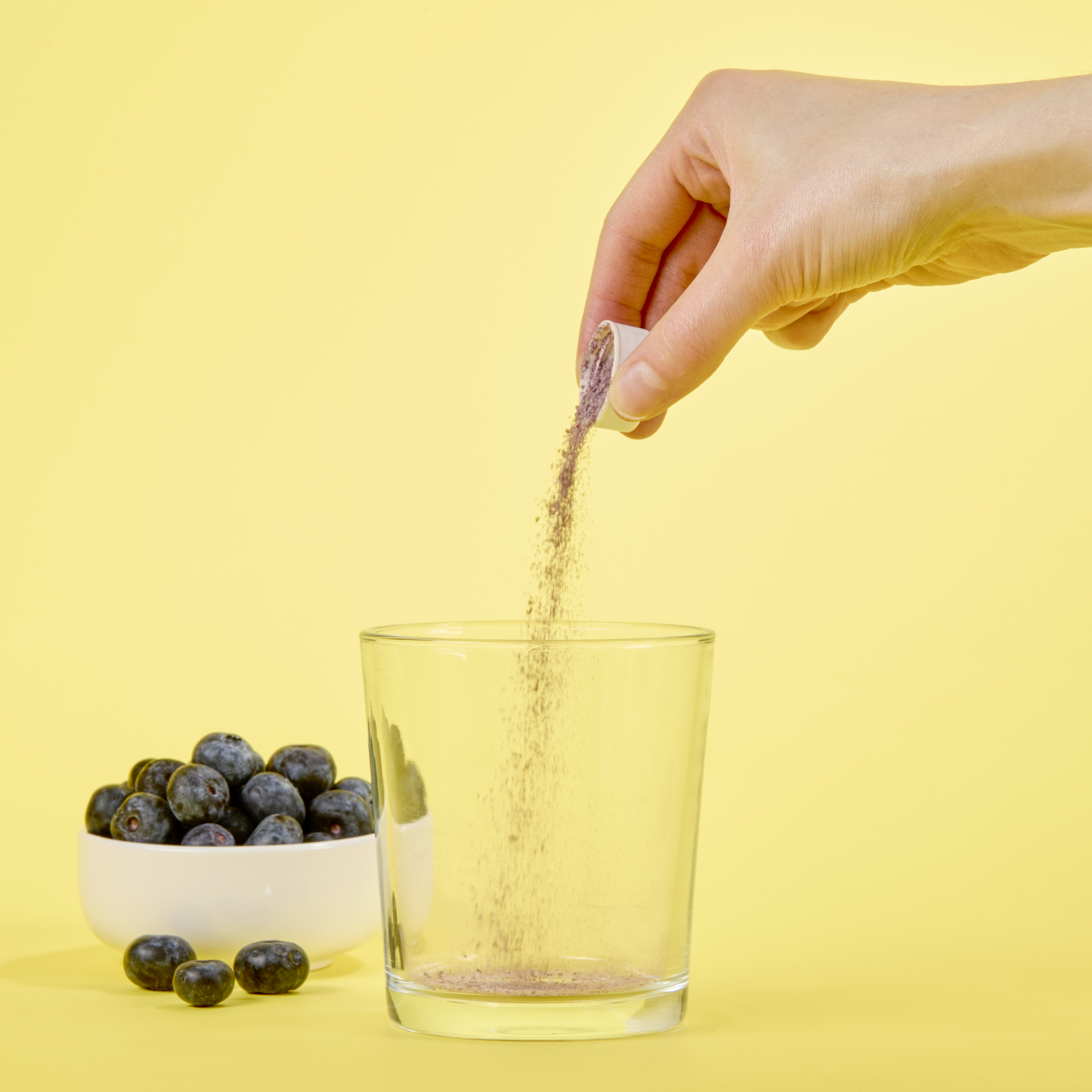 image of a hand pouring Isotonix Reseveratrol into a clear glass