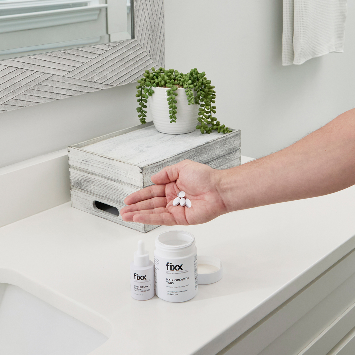 image of Fixx Hair Growth Tabs bottle with four tablets beside a glass of water