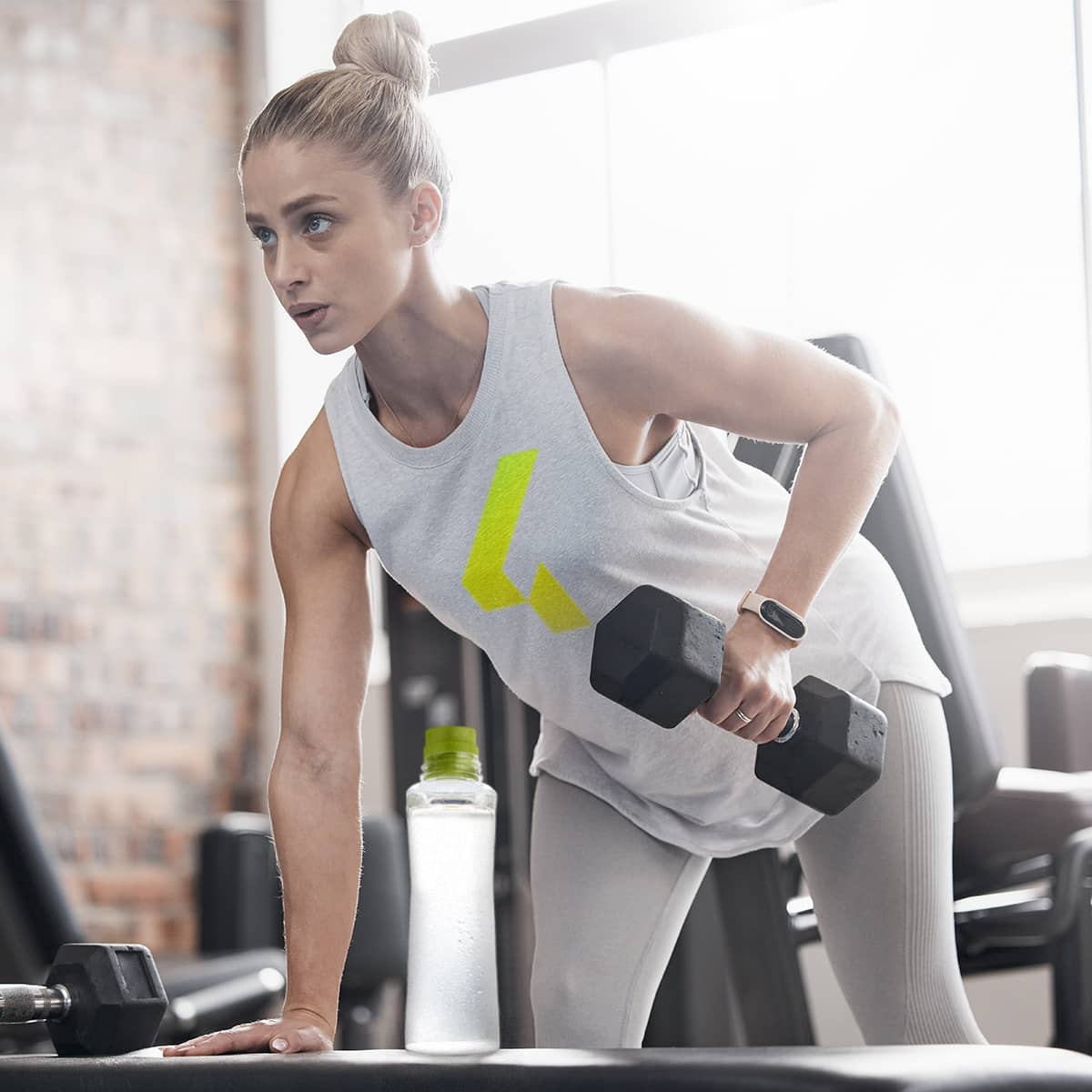 image of a woman after working out drinking Tower+ Electrolyte Mix