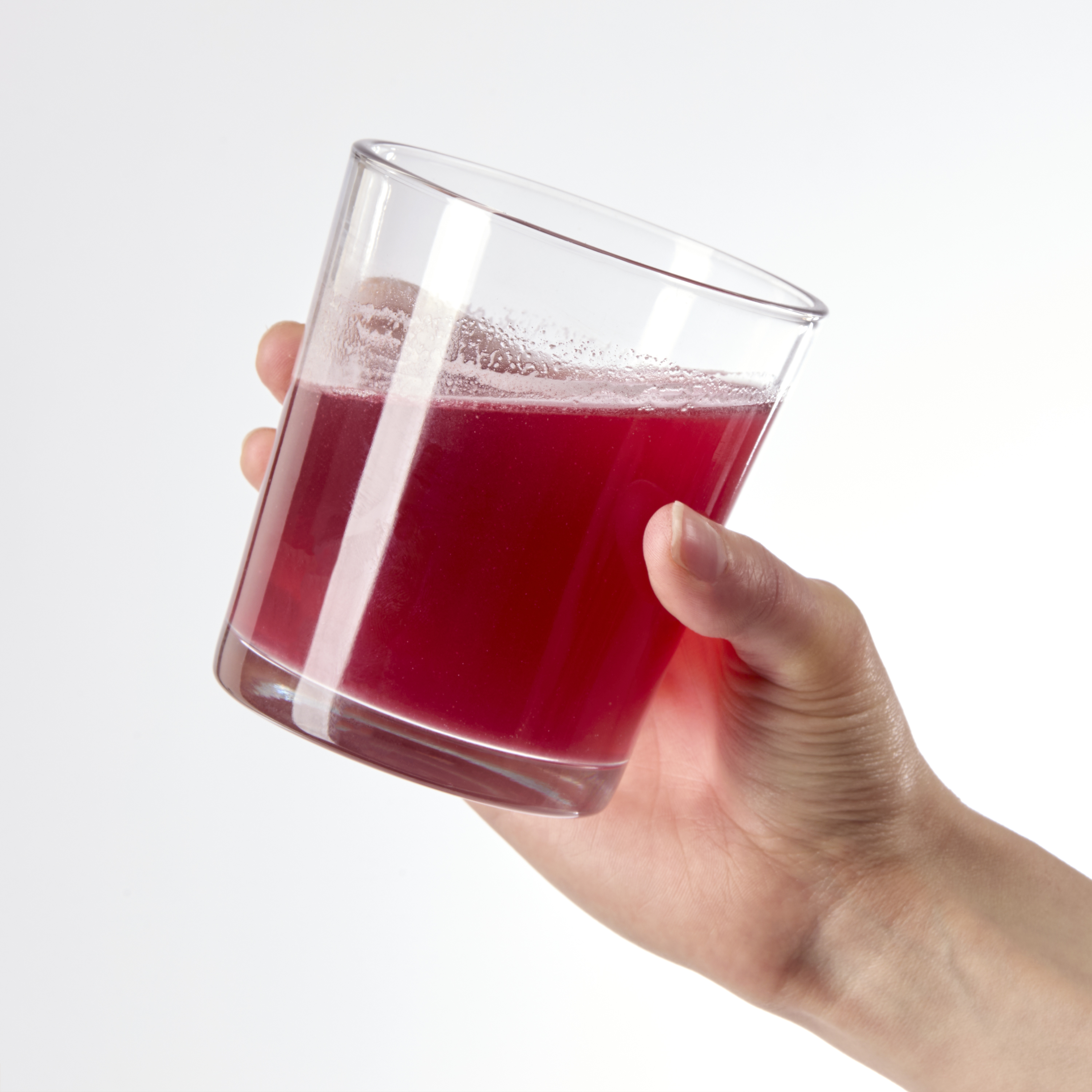 image of person's hand lifting glass to drink product
