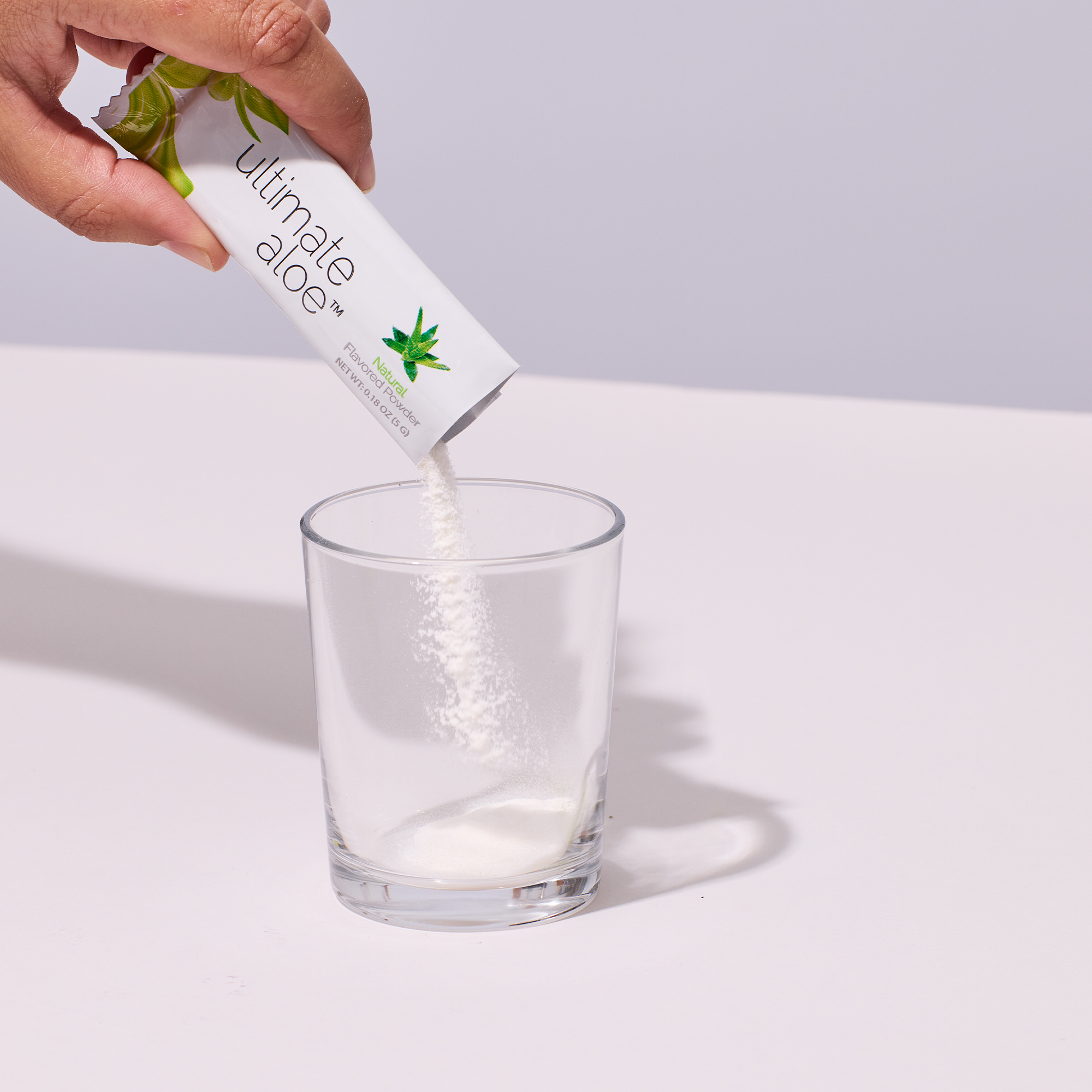 image of person pouring Ultimate Aloe™ powder in a cup.
