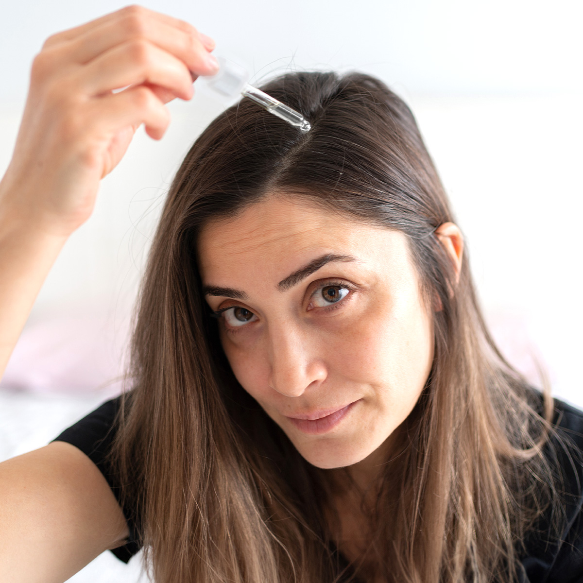 image of woman applying serum to scalp
