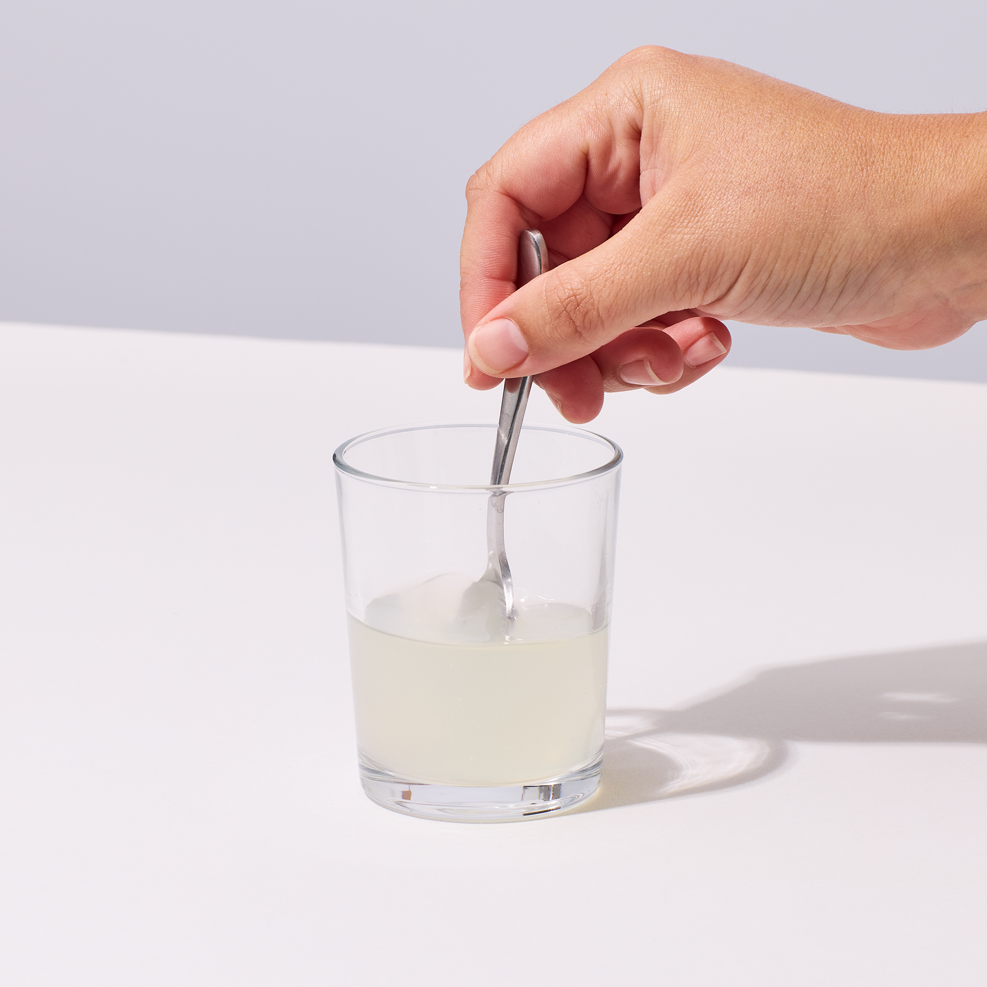 image of person mixing up IX Magnesium with 2 oz of water in a glass