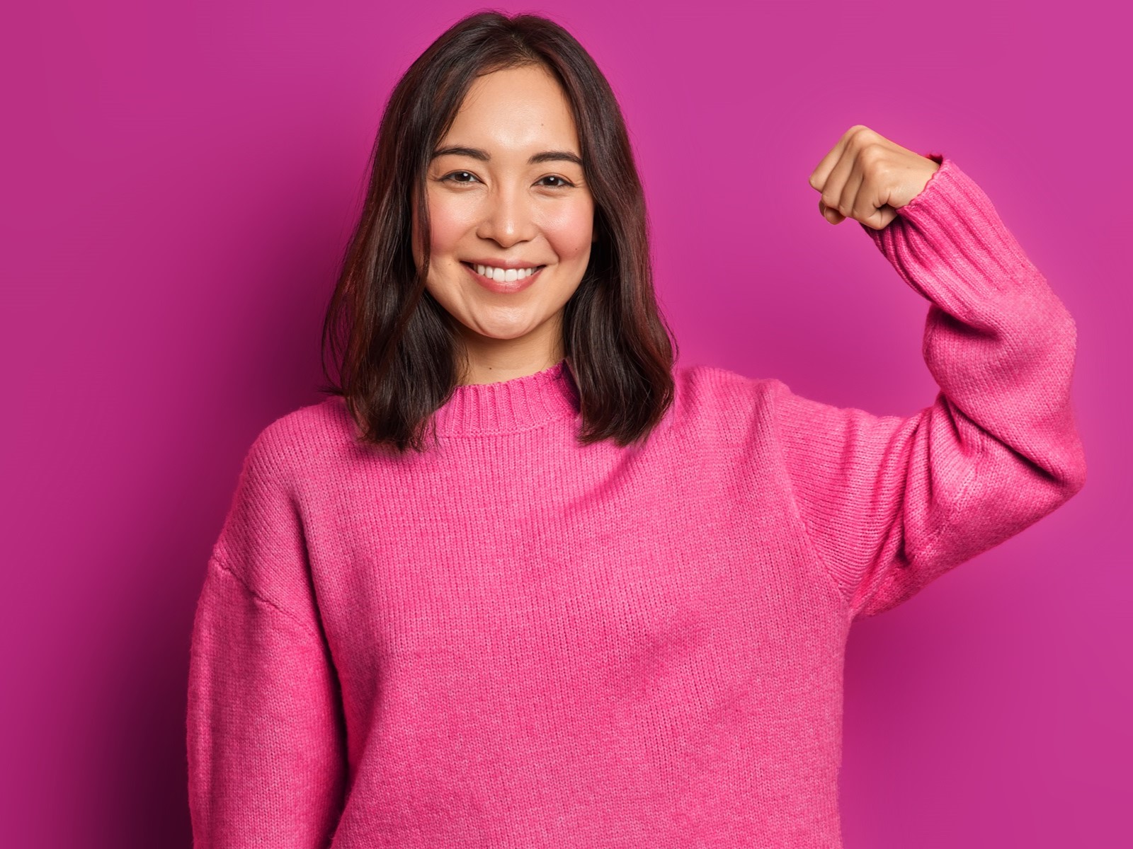 image of woman in pink sweater flexing arm muscle