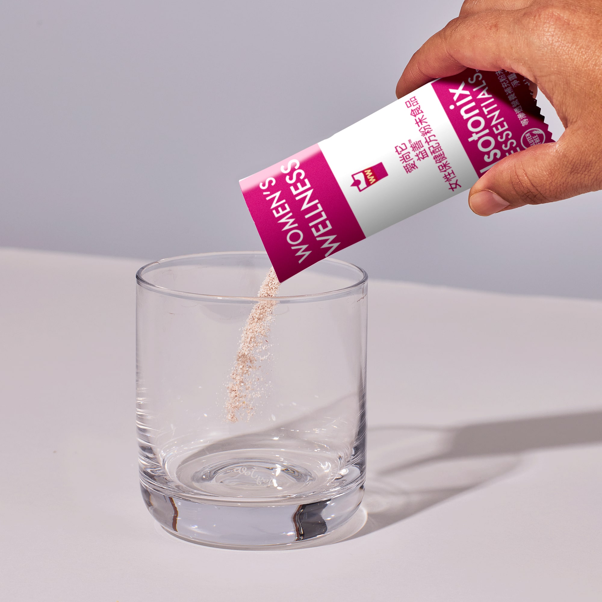 image of person adding packet of powder to glass