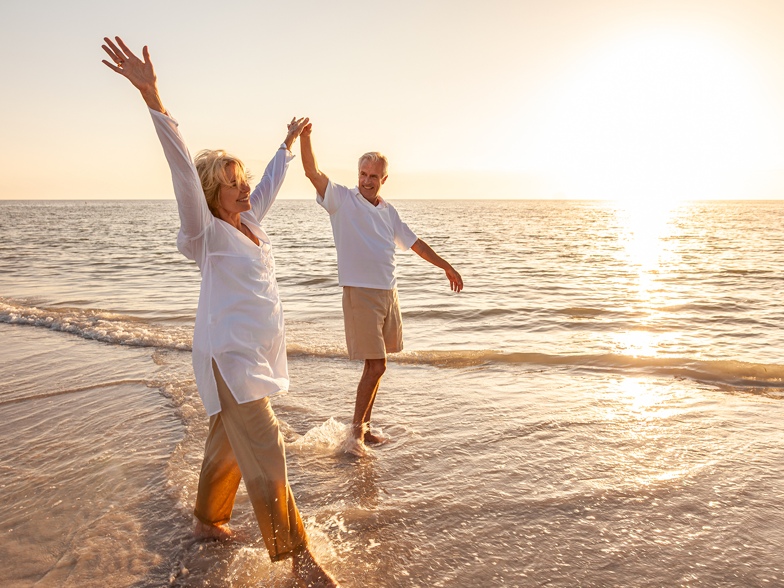Image of two people holding hands in the sunshine