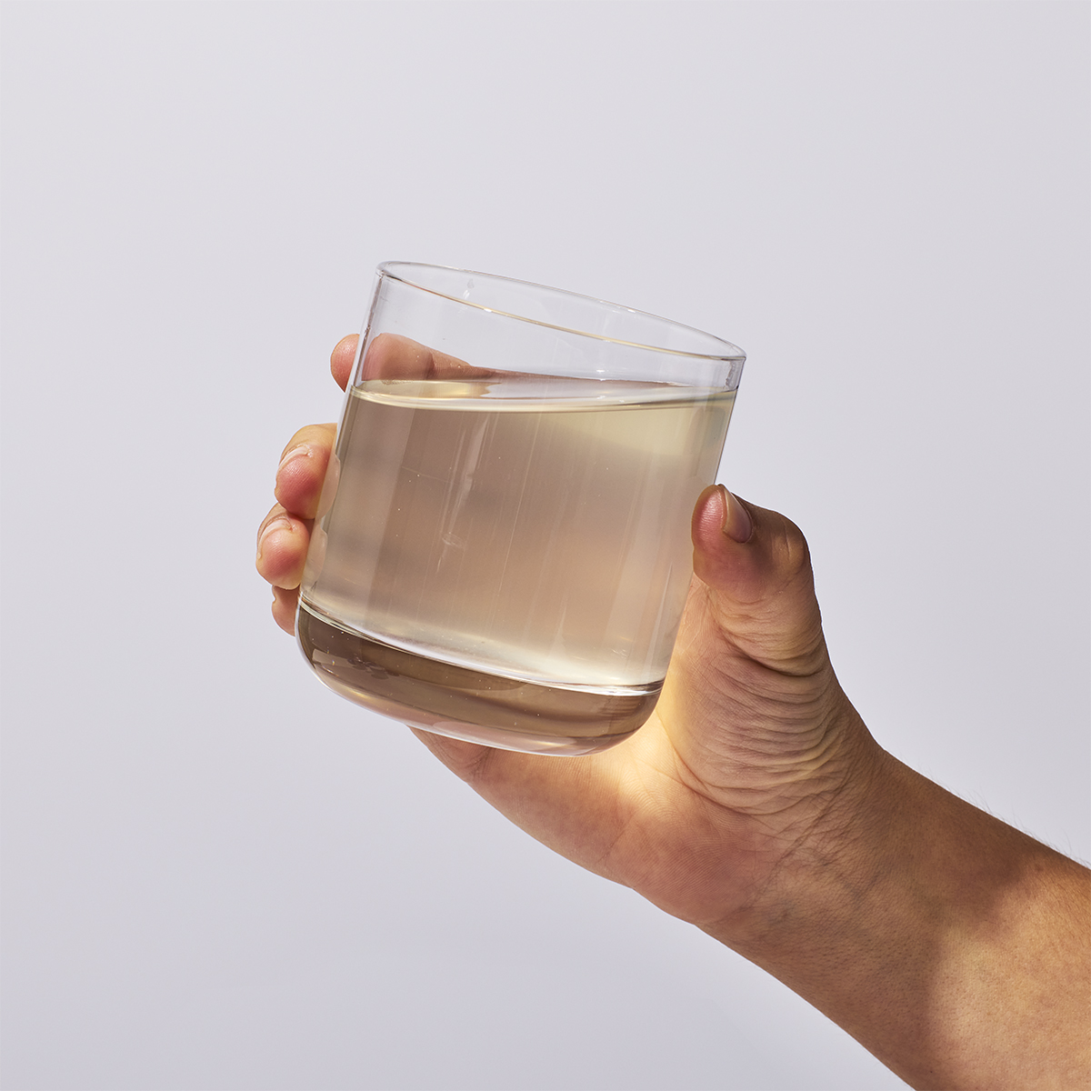 image of someone's hand pricking up the glass containing one serving of NutriClean Advanced Fiber Powder